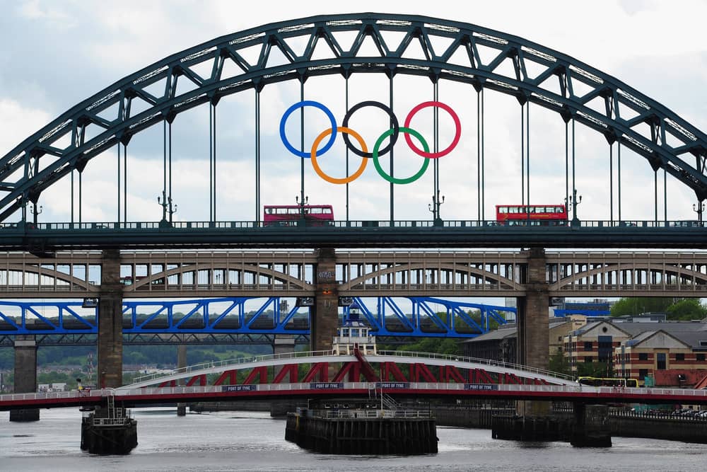 A London bus crosses the Tyne Bridge as the city of Newcastle prepares for the Olympic Torch Relay by displaying the Olympic rings on the landmark .