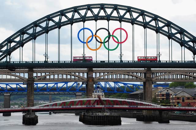 A London bus crosses the Tyne Bridge as the city of Newcastle prepares for the Olympic Torch Relay by displaying the Olympic rings on the landmark .
