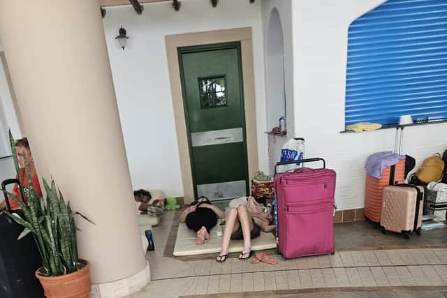 People evacuated from hotels in Rhodes lie on mats on the floor at an abandoned school.