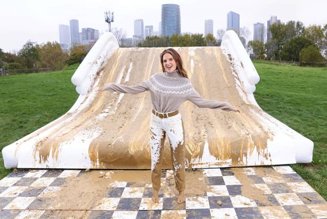 Binky Felstead encourages families to embrace the mud this half term as she's spotted going down a 2.5m high mudslide, created by Bosch at Mudchute Farm.