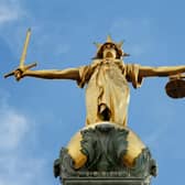 View of the gold statue of the figure of justice, holding scales and a sword, on top of the Old Bailey, in central London
