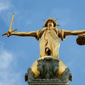 View of the gold statue of the figure of justice, holding scales and a sword, on top of the Old Bailey, in central London