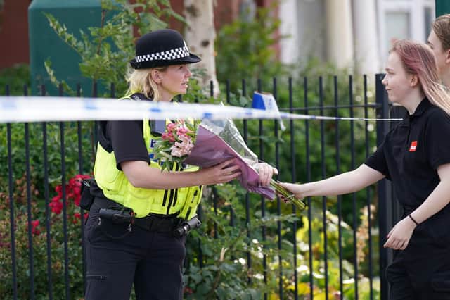 A woman arrives to leave flowers at the scene of a house fire on August 26 in Middlesbrough