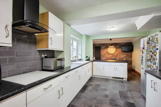 The spacious kitchen and dining area combines practical fitted features with room for a table, chairs and a breakfast bar