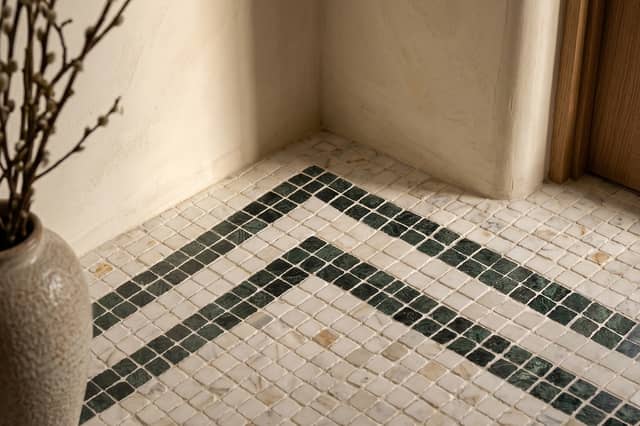 ROMAN LUXURY Lapicida’s Calacatta Gold Marble Mosaic creates an elegant statement floor with contrasting Verde Guatemala detailing.