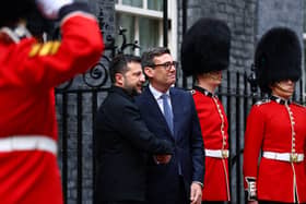 Volodymyr Zelensky and Andy Burnham shake hands outside 10 Downing Street, flanked by soldiers in red dress uniform