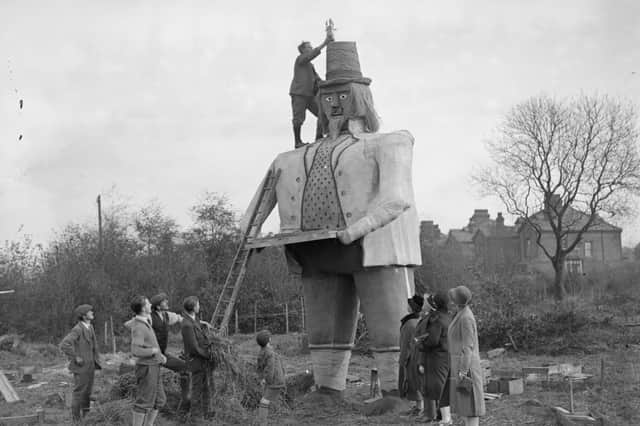 Mr C W Clarke putting a rocket on the hat of his 23ft Guy Fawkes effigy in November 1927.