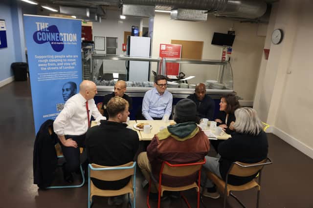 Prime Minister Andy Burnham and Chancellor of the Exchequer John Healey speaking to service users during a visit at St Martin-in-the-fields. Credit: PA