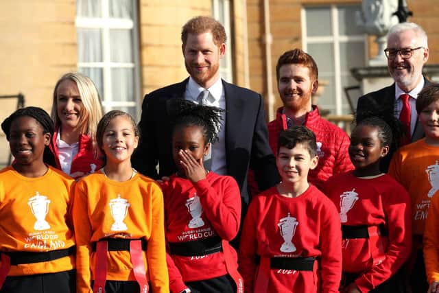 The Duke of Sussex standing with children playing rugby in the Buckingham Palace gardens, London, as he hosts the Rugby League World Cup 2021 draws. Picture: Yui Mok/PA