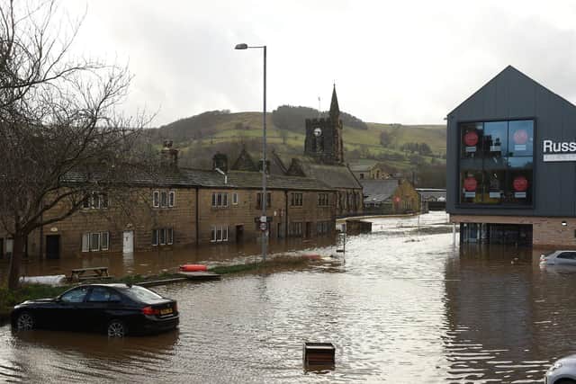 Cars are seen submerged as flood water covers the roads and car parks in Mytholmroyd. Credit: Getty/Oli Scarff