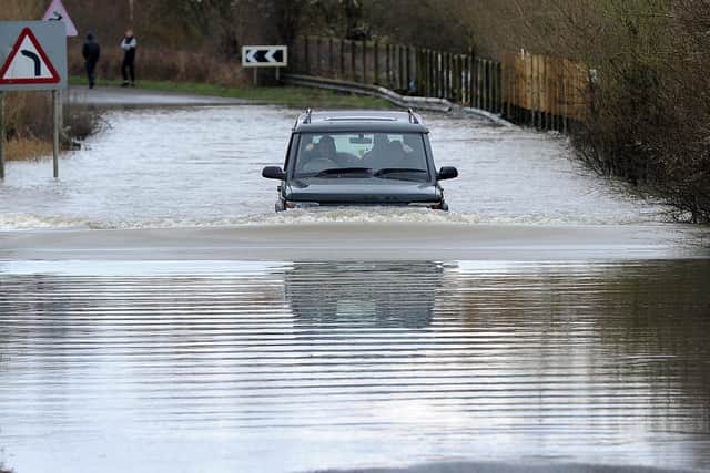 A car drives through a flooded road on Newton Lane, Fairburn Ings, near Castleford.
