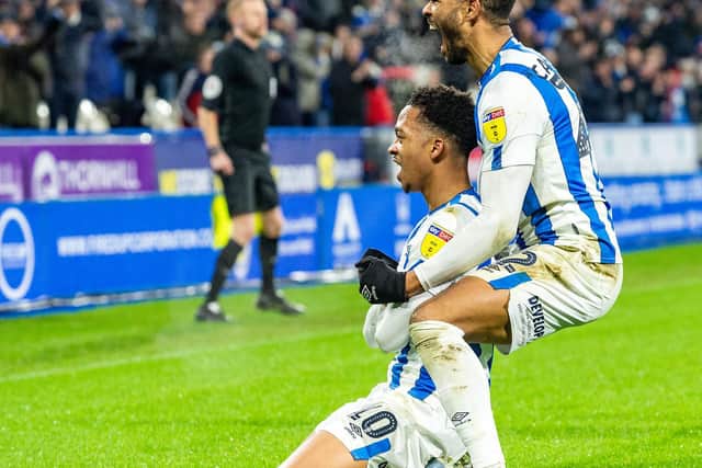 Chris Willock (kneeling) and Fraizer Campbell celebrate the latter's first Huddersfield Town goal