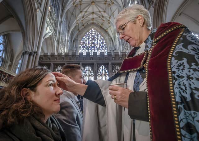 At York Minster, Lisa Power and Danny Knight receive the sign of the cross marked in ashes on their foreheads, from The Revd Maggie McLean, Canon Missioner at York Minster, during the Imposition of Ashes on Ash Wednesday.