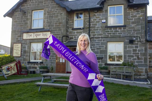 Jayne Sivills outside the Tiger Inn with a Lady Buttons scarf.