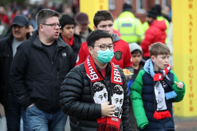 A fan in a mask at last weekend's Manchester Derby as cases of coronavirus escalate.
