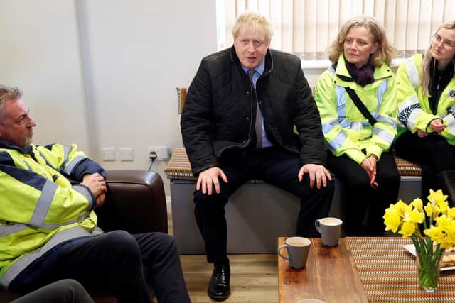 Prime Minister Boris Johnson speaks to emergency workers during his visit to Bewdley in Worcestershire on a visit to see recovery efforts following recent flooding in the Severn valley.