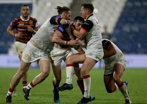 Held up: Huddersfield Giants’ Jake Wardle is tackled by two Toronto Wolfpack players as the Canadian side got their first win. (Picture: PA)