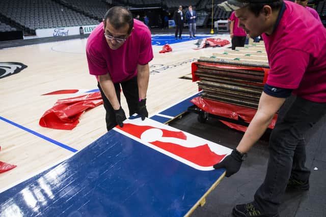 Crews break down the court after the Dallas Mavericks defeated the Denver Nuggets in an NBA basketball game on Wednesday, March 11, 2020 at American Airlines Center in Dallas. (Ashley Landis /The Dallas Morning News via AP)