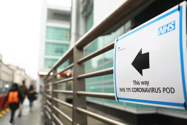 A sign directs directs patients to an NHS 111 Coronavirus Pod testing service area for COVID-19 assessment at University College Hospital in London.