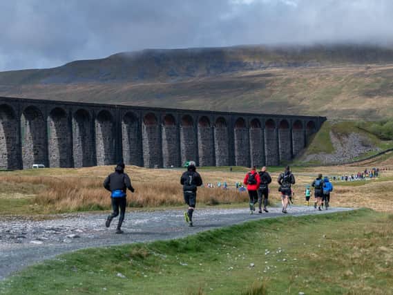 Three Peaks Race runners pass Ribblehead Viaduct