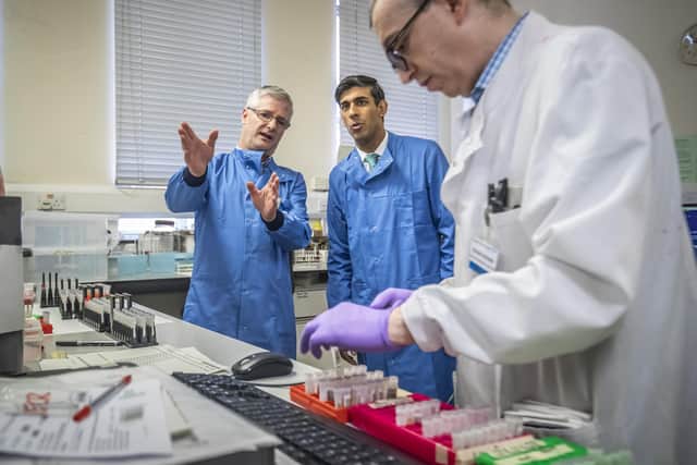 Chancellor Rishi Sunak is shown the testing of samples for respiratory viruses by Dr Antony Hale (left) during a visit to the pathology labs at Leeds General Infirmary.