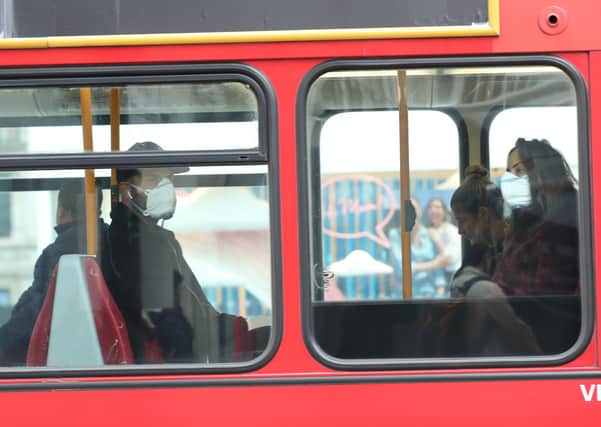 A man and woman wearing protective face masks on a bus as fears grow over coronavirus.