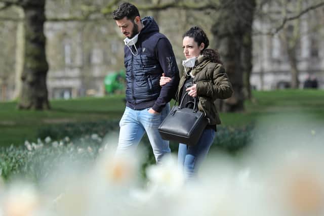 People wearing face masks in Green Park, London, as the UK's coronavirus death toll increases.