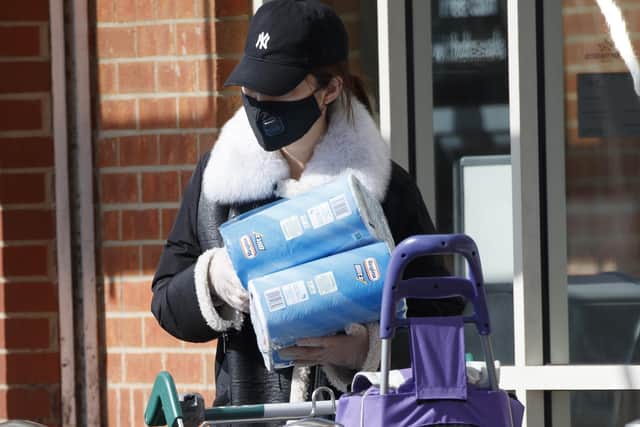 A woman wearing a face mask and protective gloves with supplies at a supermarket in York as shoppers purchase supplies amid the coronavirus pandemic.