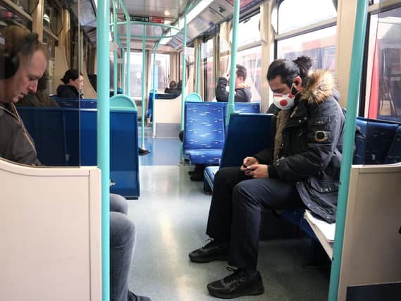 A man wears a face mask on a train in London as the public are urged to social distance and stay at home where possible. Picture: Yui Mok/PA Wire