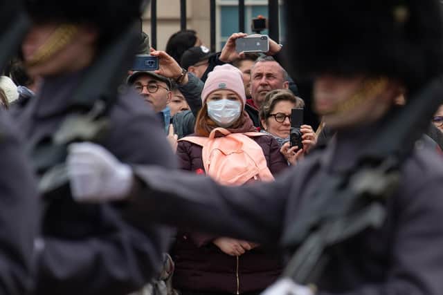 Woman in facemask watches the Changing of the Guard