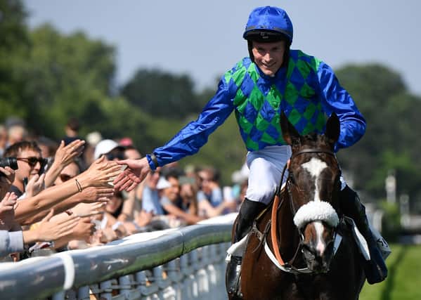 James Reveley celebrates on his horse On The Go after winning the 140th edition of the Grand Steeple-Chase de Paris.