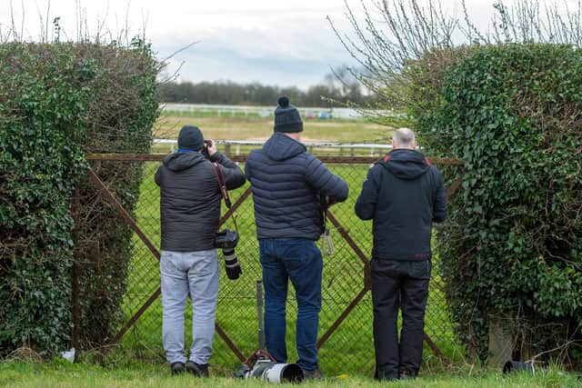 Photographers and spectators watch the racing at Wetherby from the back straight.
