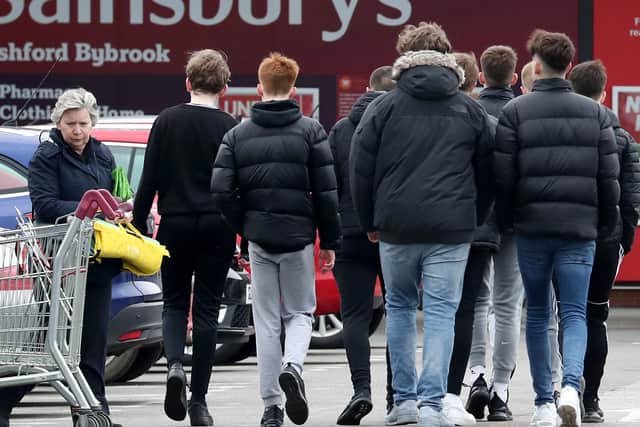 A group of teenage boys head for a supermarket after the country was put on shutdown.