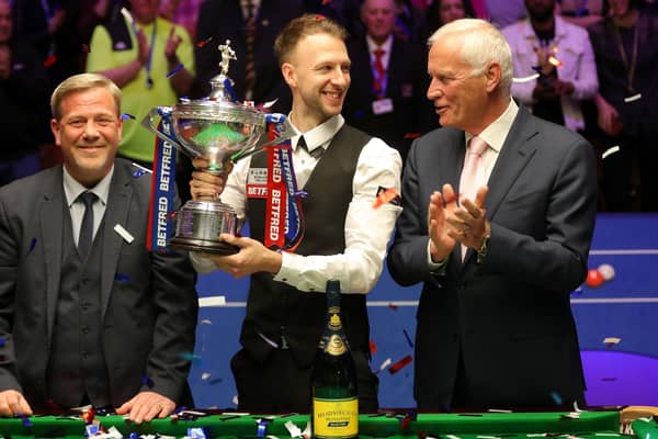Judd Trump (centre) celebrates with the trophy after winning the 2019 Betfred World Championship alongside Barry Hearn (right).