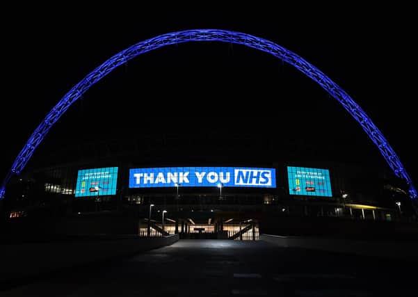 Wembley Arch is illuminated in blue to show its appreciation to the NHS amid the coronavirus outbreak in London, after Prime Minister Boris Johnson ordered pubs and restaurants across the country to close tonight as the Government announced unprecedented measures to cover the wages of workers who would otherwise lose their jobs due to the coronavirus outbreak. PA Photo. Picture date: Friday March 20, 2020. See PA story HEALTH Coronavirus. Photo credit should read: Kirsty O' Connor/PA Wire