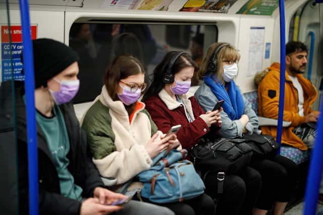 Commuters wear masks as a precaution whilst travelling on a London Underground train. Photo: Tolga AKMEN / AFP