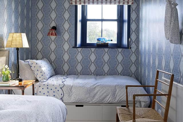 Ikea beds are topped with vintage linens, the antique Cotswolds chair belonged to Rita's father, the Roman blind is in a Titley and Marr print, and the wallpaper is by Nina Campbell