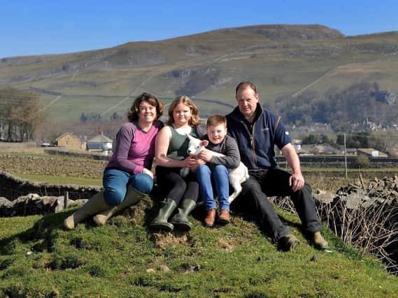 Farmer John North pictured with his wife Alison and children Isobel aged 10 and John aged 8, with a lamb, on their farm near Giggleswick.. Picture by Simon Hulme