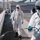 Firefighters of the Burgos City Council disinfect the entrance to the Burgos Hospital in northern Spain on March 23, 2020 amid a national lockdown to fight the spread of the COVID-19 coronavirus. Photo by CESAR MANSO / AFP.