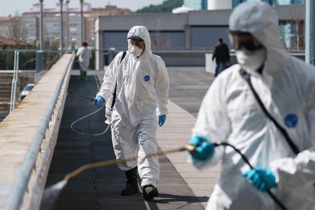 Firefighters of the Burgos City Council disinfect the entrance to the Burgos Hospital in northern Spain on March 23, 2020 amid a national lockdown to fight the spread of the COVID-19 coronavirus. Photo by CESAR MANSO / AFP.