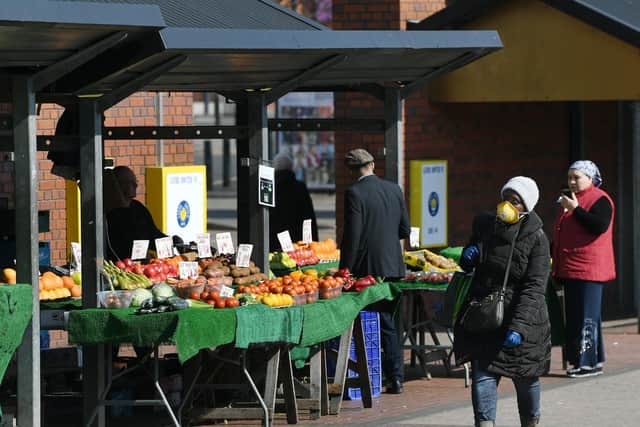 Customers at the outdoor market in Leeds take precautions (photo: Jonathan Gawthorpe).