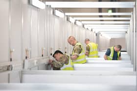 Soldiers and private contractors help to prepare the ExCel centre, London, which is being made into the temporary NHS Nightingale hospital, comprising of two wards, each of 2,000 people, to help tackle coronavirus.