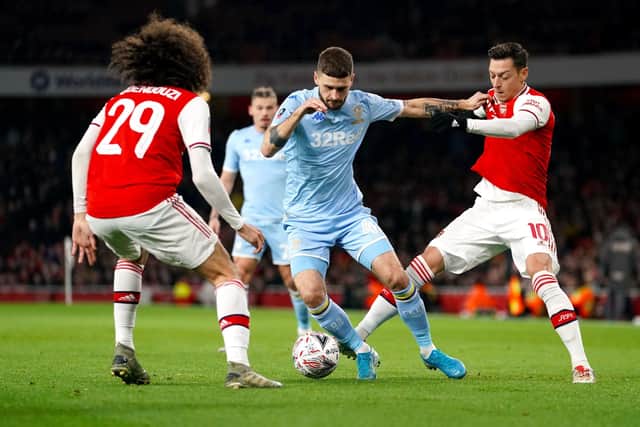 IN THE THICK OF IT: Leeds United's Mateusz Klich (centre) battles for the ball with Arsenal's Matteo Guendouzi (left) and Mesut Ozil. Picture: John Walton/PA