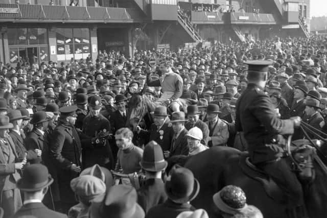 Surrounded by a huge crowd, Jim Hamey leads in 'Forbra' who won the Grand National in 1932 (Picture: W. G. Phillips/Topical Press Agency/Getty Images)