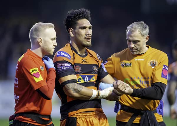 Castleford Tigers doctor Nick Raynor (left) and physio Matty Crowther (right) carry Jesse Sene-Lefao off with an injury. Picture: Allan McKenzie\SWpix.com.
