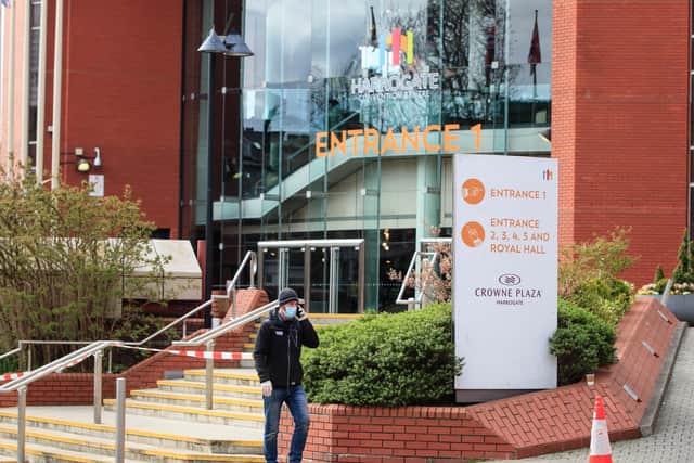 A man wearing a facemask walks past the Harrogate Conference Centre.