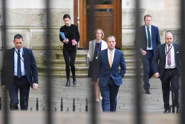 Foreign Secretary Dominiv Raab is flanked by senior officials and protection officers.