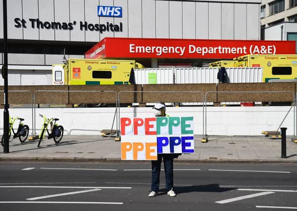 A demonstrator holds signs saying PPE outside St Thomas' Hospital in Central London where Prime Minister Boris Johnson is in intensive care as his coronavirus symptoms persist.
