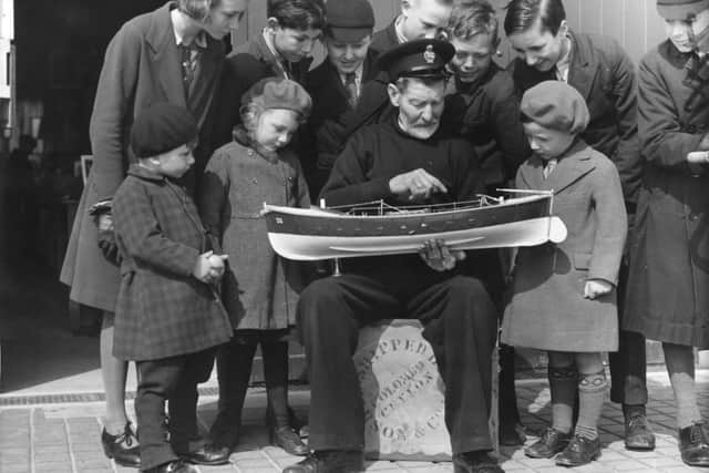30th April 1937:  An old lifeboat man shows some schoolchildren a model of a lifeboat at the Royal National Lifeboat Institution (RNLI) museum in Eastbourne.  (Photo by Derek Berwin/Fox Photos/Getty Images)