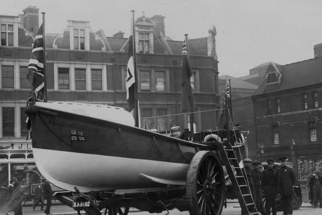 circa 1912:  A Royal National Lifeboat Institution (RNLI) boat with the unusual name of D7 Robert And Catherine arrives in Brixton market, London on Lifeboat Day. Founded in 1824, this charity-funded organisation saves around 1,600 lives a year in Britain.  (Photo by General Photographic Agency/Getty Images)